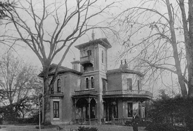 Smiley's Castle, or Rose Arden, a buff-brick mansion with large trees and a man standing in front